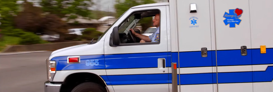 Bangs ambulance driver turning on a suburban road