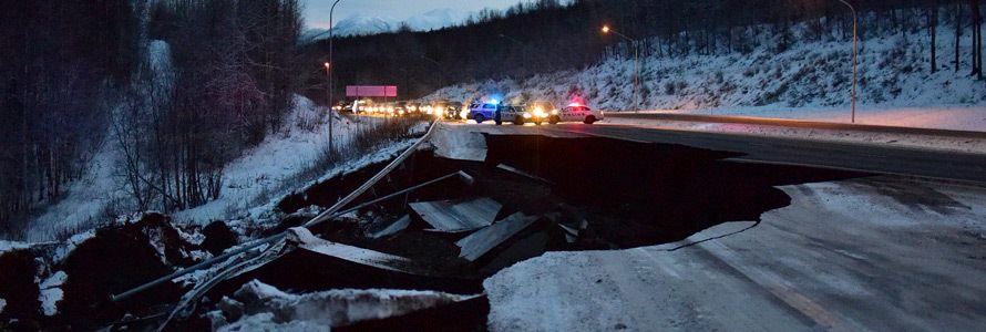 First responder vehicles on a highway destroyed by earthquake