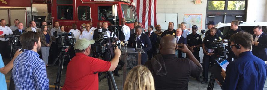 First responders inside a firehouse holding a press conference