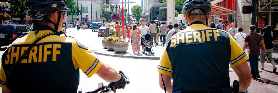 Two first responders on a city street with pedestrians