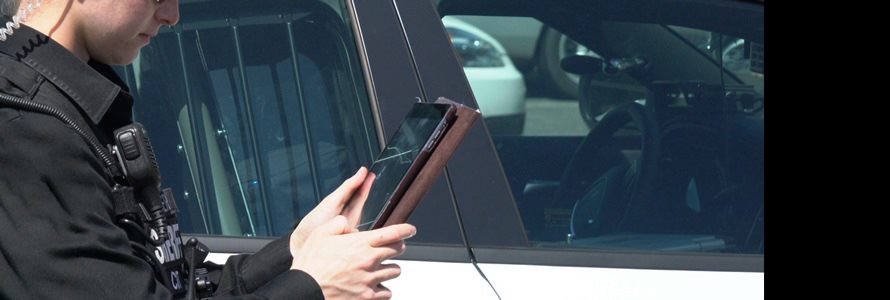 First responder outside their vehicle holding a tablet