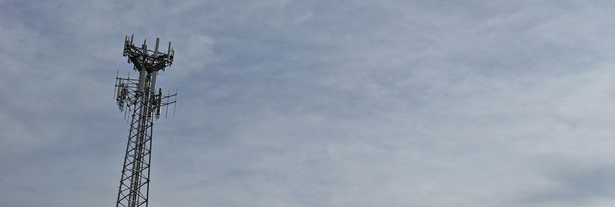 Cell tower against cloudy sky