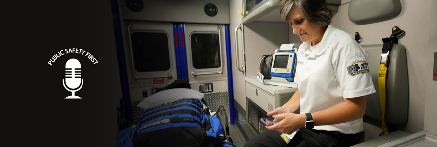 Public Safety First podcast logo; EMS official sits in ambulance and holds smartphone in hand