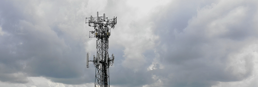 A cell tower in front of a cloudy sky