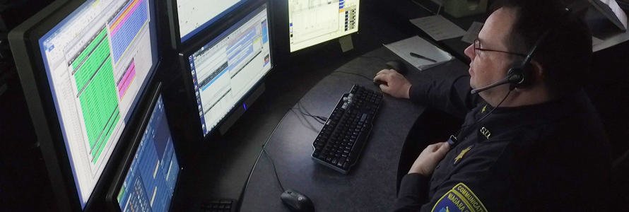 Male dispather viewing a bank of monitors at his desk