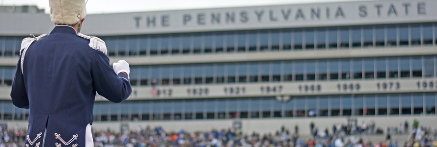 Band member standing in Beaver Stadium during daytime