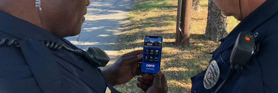 Two police officers looking at content from smart device 