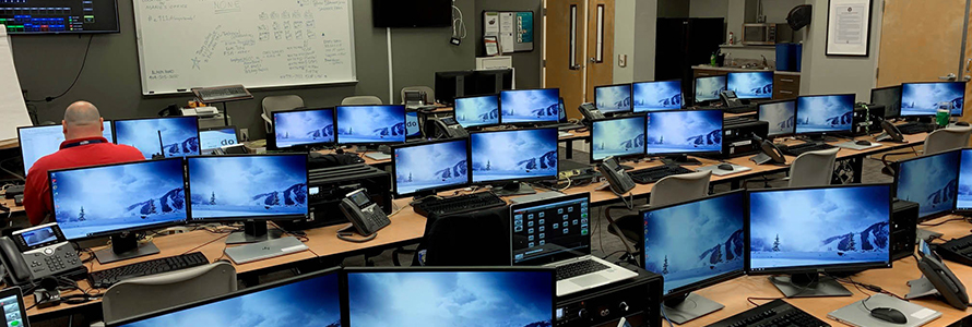 APCO_repost: A man sits surrounded by rows of monitors set up to serve as a mobile command center for Fulton County.