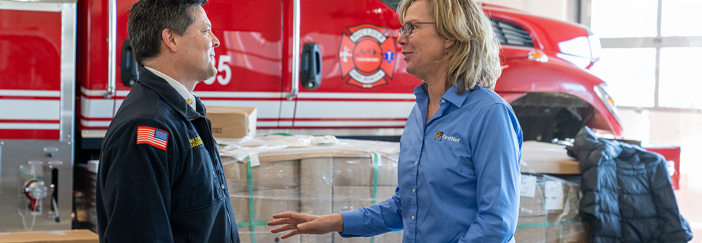 Boulder Fire-Rescue Chief Michael Calderazzo and FirstNet Authority Senior Public Safety Advisor Tracey Murdock stand talking in front of a fire truck