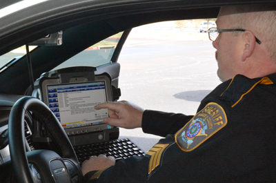 A Brazos County Sheriff's Department officer looks at a screen inside of his patrol car