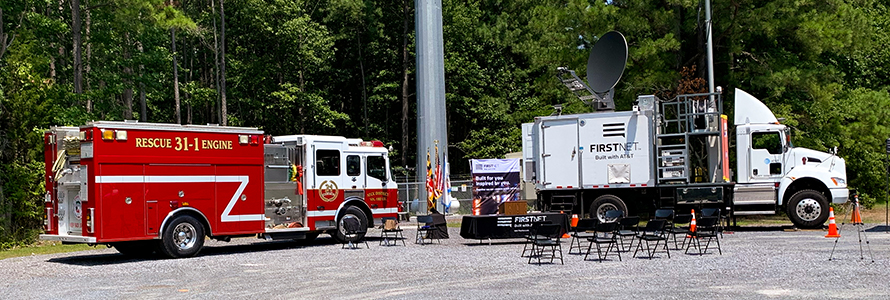 Fire truck and FirstNet Satellite Cell on Light Truck parked in front of a cell tower