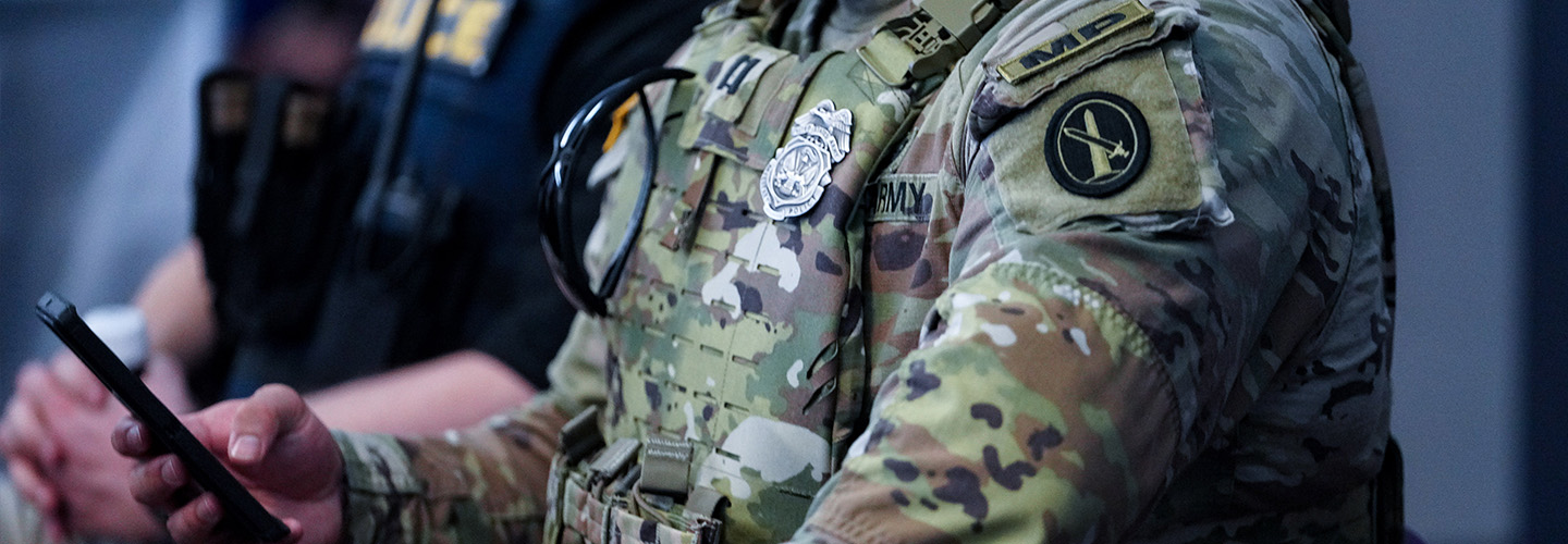 An army military police officer using a FirstNet enabled cell phone