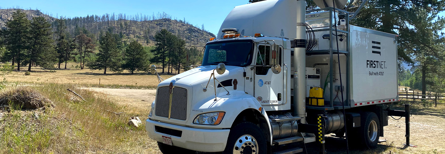 A FirstNet Satellite Cell on Light Truck parked outside and surrounded by trees