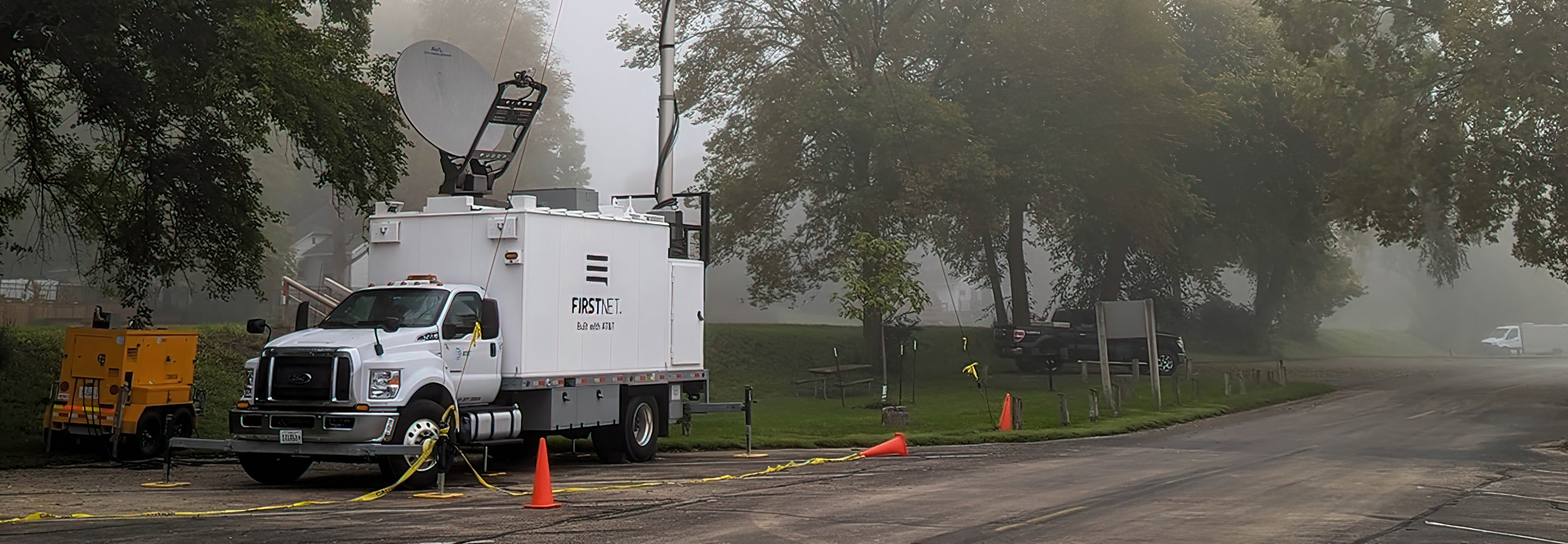 A FirstNet SatCOLT set up along a rural street on a foggy day.