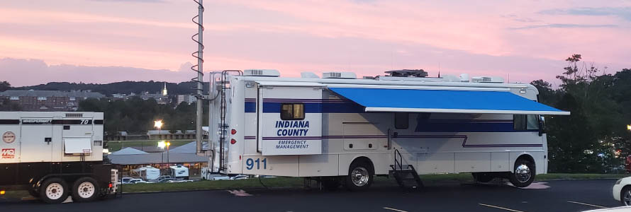 An Indiana County Emergency Management vehicle sits in a parking lot at sunset.