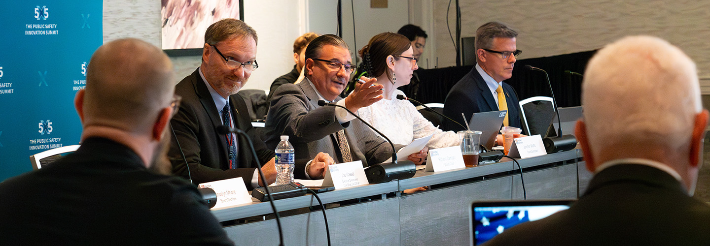 Board Chair Chief Richard Carrizzo, seated next to Executive Director Joe Wassel, gestures towards a fellow board member