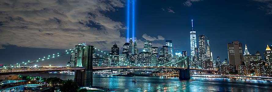 New York City skyline with two beams of light in the sky marking September 11 remembrance 