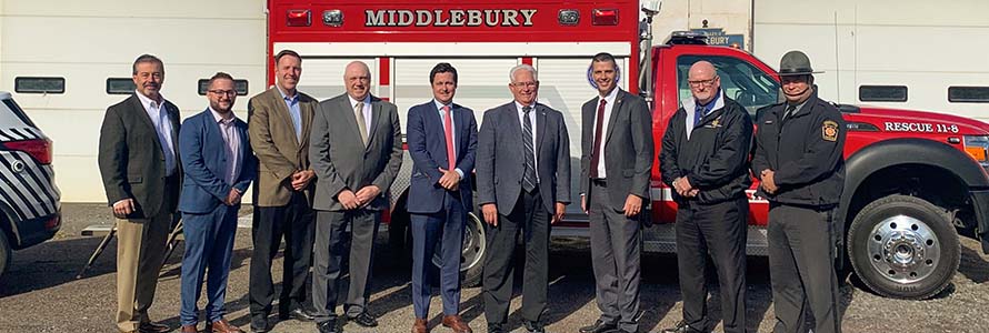 Local leaders and FirstNet Authority staff stand in front of a Middleburg ambulance