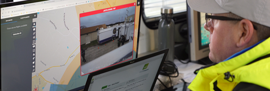 A first responder watches a video feed on a computer during an incident.