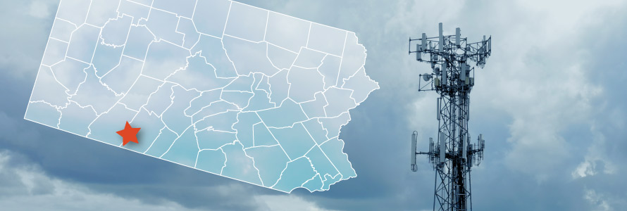 The state of Pennsylvania, with outlined county borders; star marking Hyndman in Bedford County; a FirstNet cell tower