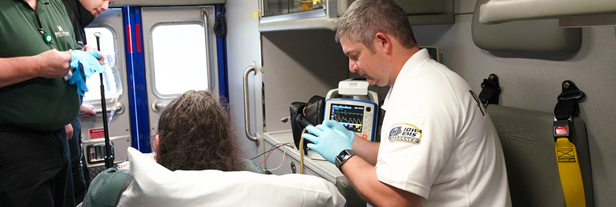 Emergency medical services personnel tend to a patient in an ambulance. 