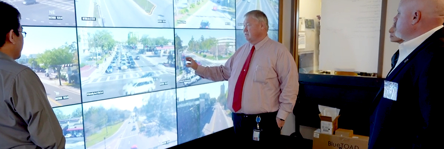 Public works staff from Gainesville, Florida consult several screens showing live stream video from around the city. 