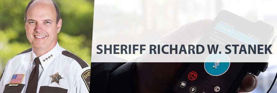 On left, headshot of Sheriff Richard Stanek in uniform, on right, a hand holds a FirstNet device with an app on it