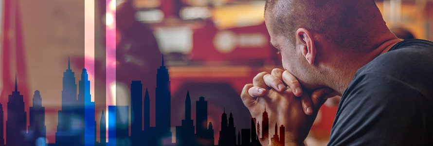 First responder somberly looking away; silhouette of New York City skyline with World Trade Center tower remembrance silhouettes