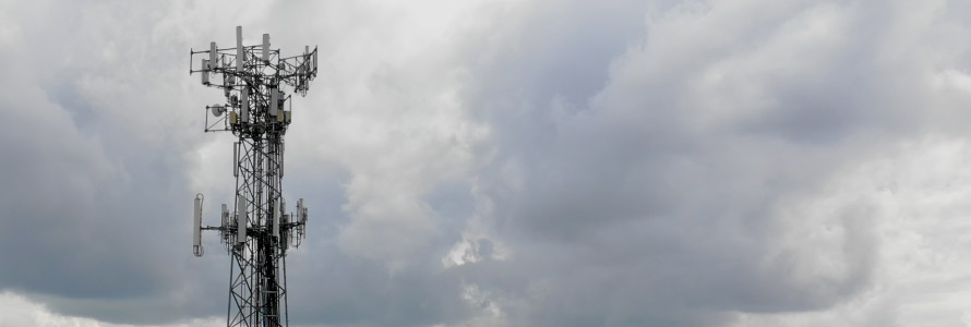 A cell tower in front of a cloudy sky