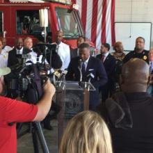 First responders inside a firehouse holding a press conference