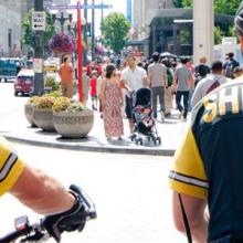 Two first responders on a city street with pedestrians