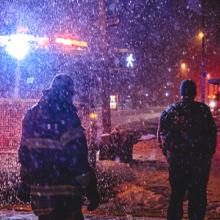 Firefighter standing by fire engine at snow covered city street