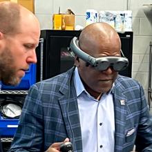 The First Responder Network Authority board chair Stephen Benjamin wearing a pair of virtual reality goggles during a lab tour.