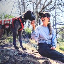 First responder in the woods with her search and rescue dog