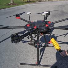 Police officer prepares drone on street; Public Safety First podcast logo; “Eyes in the Sky: Drones and FirstNet”