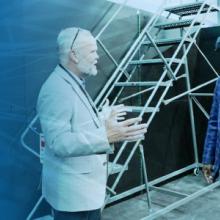 Public Safety First podcast logo; Public Safety Communications Research Division Chief Dereck Orr speaks to FirstNet Authority Board Chair Stephen Benjamin while Benjamin wears virtual reality goggles; overlapping lines