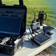 Episode 69 FirstNet goes to school: Keeping Maryland students safe with public safety broadband FirstNet-enabled devices on a table outside; Public Safety First podcast icon