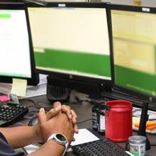 An emergency dispatcher sits in front of an emergency response system with his headset on.