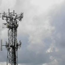 A cell tower in front of a cloudy sky