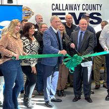 Local leaders cut a ribbon in front of a Callaway County EMS ambulance