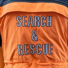 Episode 85: Live at 5x5: Clearing the Air — The Digital Evolution of Search and Rescue Search & Rescue jacket; attendees at 5x5: The Public Safety Innovation Summit listening to the Clearing the Air panel; Public Safety First podcast logo
