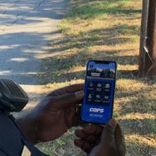 Two police officers looking at content from smart device 