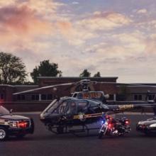 An Oakland County Sheriff’s Office SUV, helicopter, motorcycle, and cruiser with emergency lights activated sit outside at sunset An Oakland County Sheriff’s Office SUV, helicopter, motorcycle, and cruiser with emergency lights activated sit outside at sunset