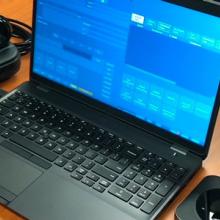 A phone, laptop, hot spot, and other dispatching equipment sit on a table.