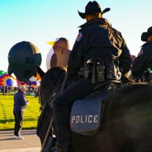 Group of New Mexico police officers riding on horseback monitoring the annual Albuquerque International Balloon Fiesta.