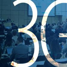 Panel discussion at the June 2025 3GPP meeting with participants seated at conference tables; two large projection screens behind the panel show presentation slides; “3GPP”