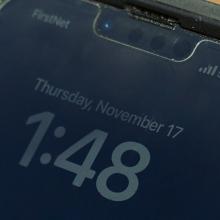 Close-up of smartphone. On screen: “FirstNet. 5G+. Tuesday, November 17. 1:48”
