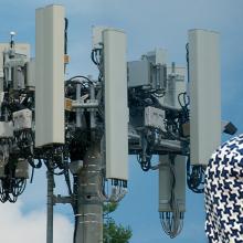 A cell tower surrounded by trees; an abstract illustration of lines; a headshot of FirstNet Authority Board Member Alexandra Fernández Navarro.