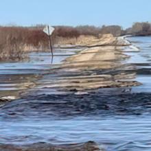 A road in Minnesota partially submerged in water from a recent flood. A road in Minnesota partially submerged in water from a recent flood.