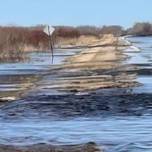 A road in Minnesota partially submerged in water from a recent flood. 